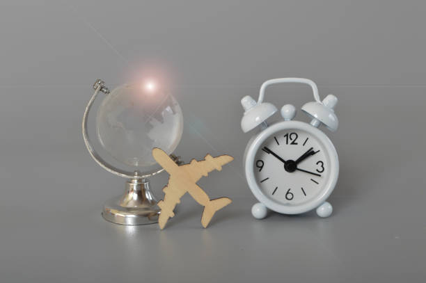 Alarm clock, flight and globe with flare. World travel globe concept isolated