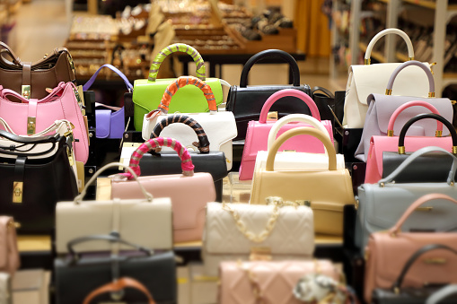 Close up female hand bags in retail store