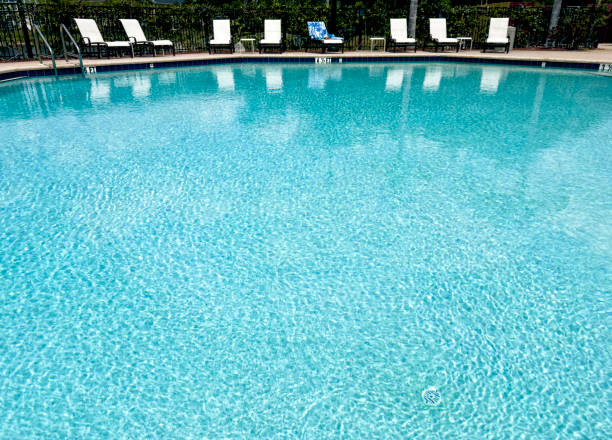 istock Water surface of swimming pool and pool chairs in a row 1496956610