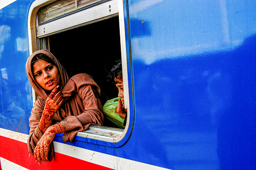 Pakistan, Karachi - March 25, 2005: young woman with tattooed hands looking out the train window