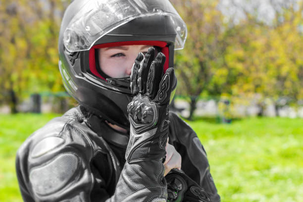 istock A girl in a motorcycle protective helmet puts on gloves 1496966139