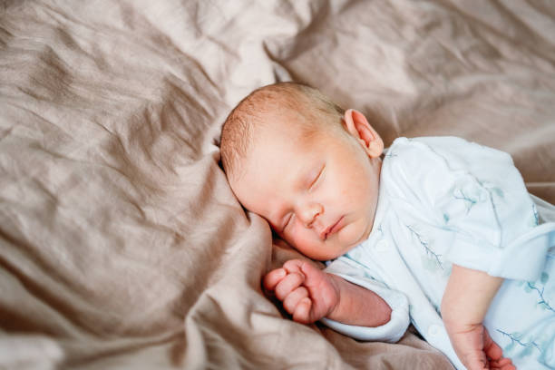 istock Little newborn baby boy sleeping in the bed 1496967549