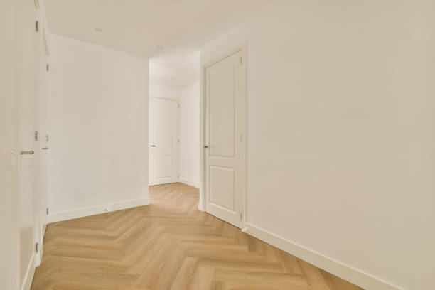 a bedroom with white walls and wood floors