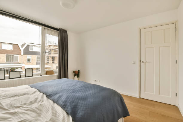 istock a bedroom with a large window and a bed 1496974926