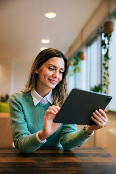istock Smiling woman using the tablet,  finishing her first project, sitting at the office. 1496977134