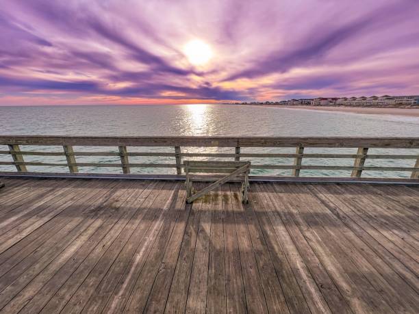 istock a view of the sun setting on a deck at a beach 1496977432