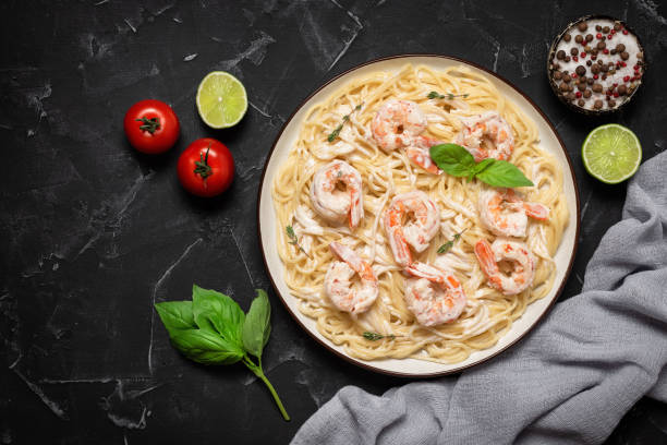 istock Spaghetti pasta with shrimps on a black stone background. Top view, flat lay, copy space. Mediterranean or Italian food. 1496979775