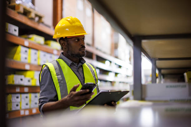 Male warehouse employee doing a checklist with RFID scanner stock photo
