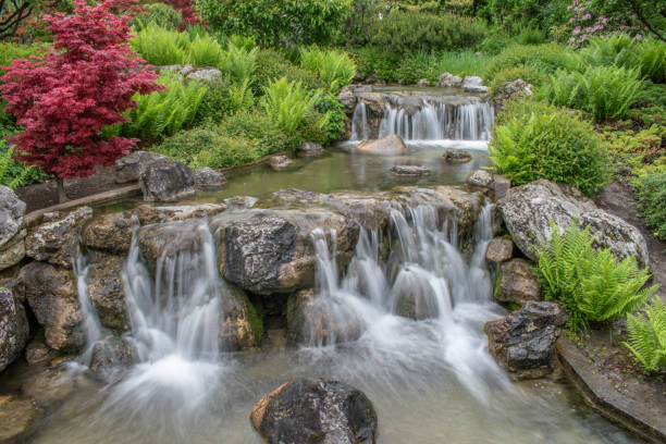 istock beautiful landscape with waterfall falling from stone wall in japanese style landscape park. Selective focus. 1496983045