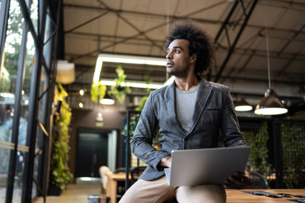Young businessman contemplating while hold a laptop at office/coworking