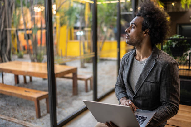 istock Young businessman contemplating while hold a laptop at office/coworking 1496986058