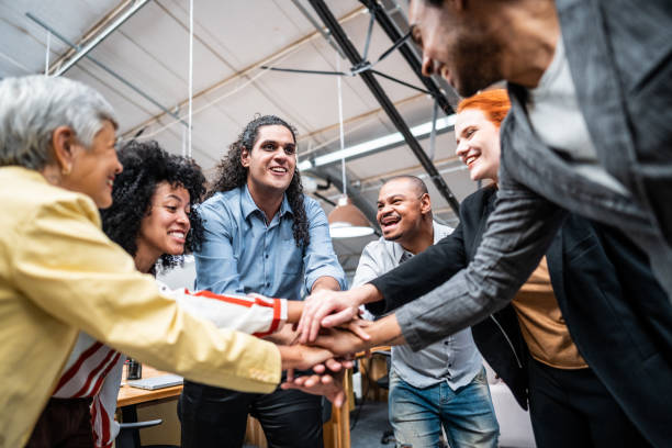 istock Coworkers with stacked hands at office 1496988531