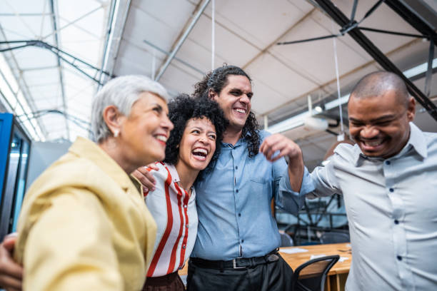 istock Coworkers embracing and celebrating at office 1496988553