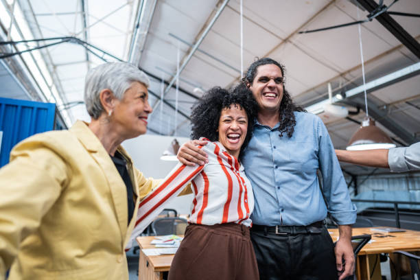 istock Coworkers embracing and celebrating at office 1496988555
