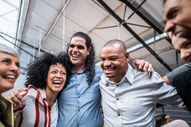 istock Coworkers embracing and celebrating at office 1496988556