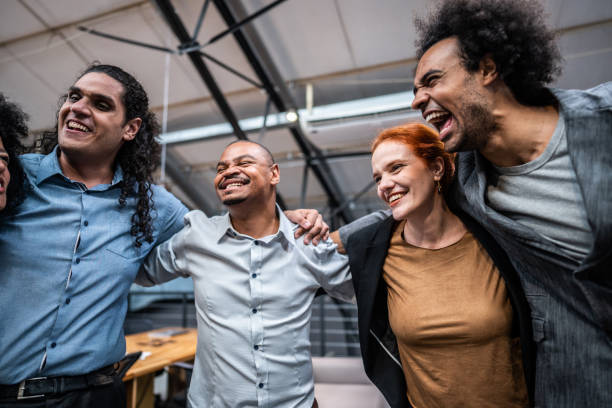 istock Coworkers embracing and celebrating at office 1496988557