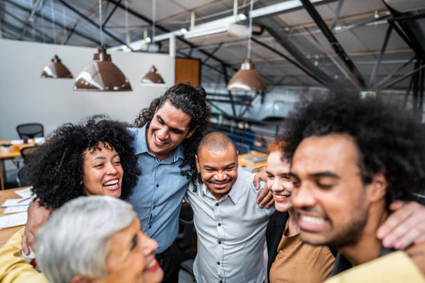 istock Coworkers embracing and celebrating at office 1496988581