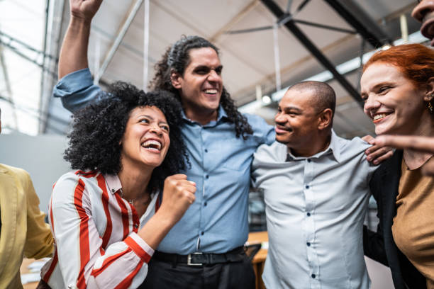 istock Coworkers embracing and celebrating at office 1496988585