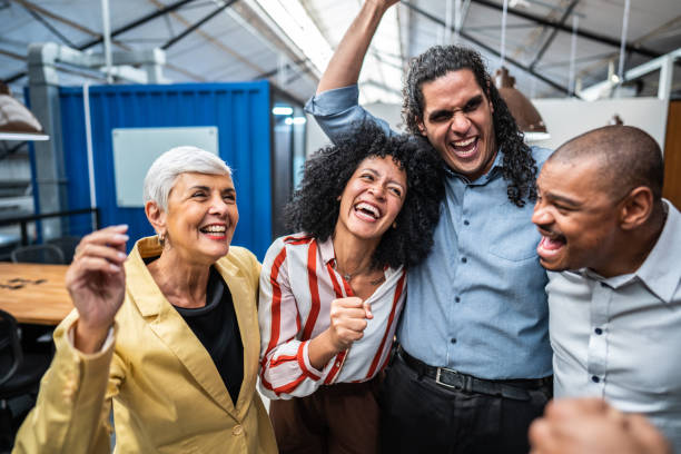istock Coworkers embracing and celebrating at office 1496988608