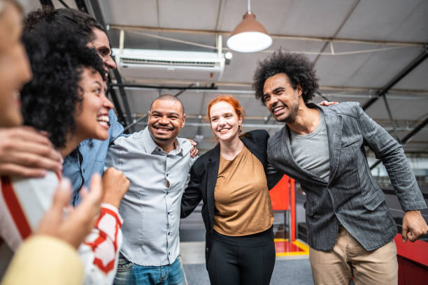 istock Coworkers embracing and celebrating at office 1496988668