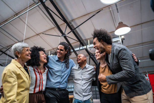 istock Coworkers embracing and celebrating at office 1496988669