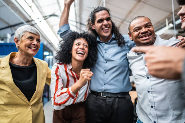 istock Coworkers embracing and celebrating at office 1496988670