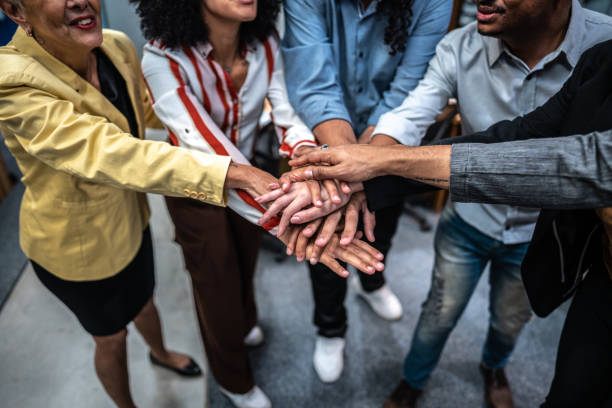istock Coworkers with stacked hands at office 1496989303
