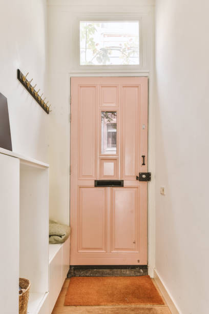 istock a pink door in a white room with a window 1496989511
