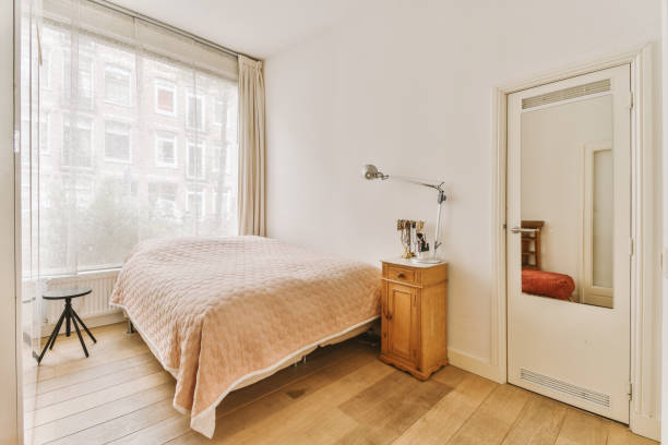 istock a bedroom with a bed and a large window 1496989525