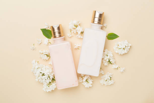 istock Composition with cosmetic bottles and flowers on color background, top view 1496991078