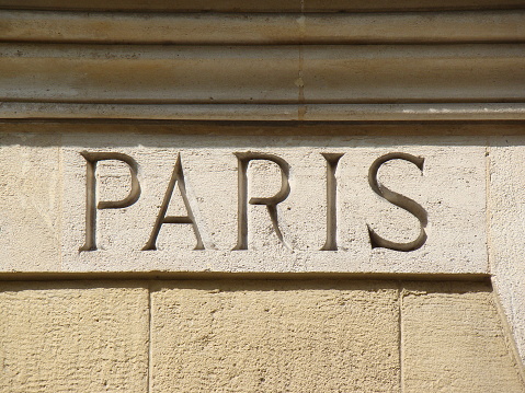 Word Paris engraved in sandstone as title or texture