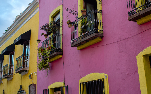 balconies in the center of the city, colonial type and very colorful next to a clear blue sky