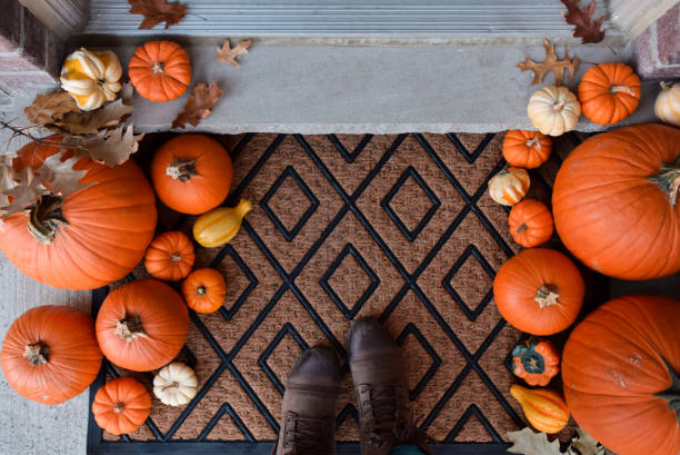istock Looking down at front porch door mat decorated with pumpkins and gourds 1496993495