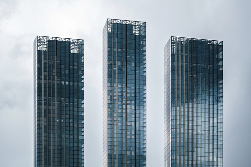 Modern skyscrapers against moody clouds forming complex block structure and pattern