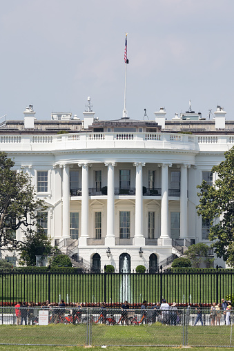 Daytime panoramic view of the northern facade of the white house featuring its classical portico with columns. The White House - US president’s official residence - is located at 1600 Pennsylvania Avenue. The neoclassical building - built between 1792 and 1800 - has been the residence of all U.S. President since John Adams.