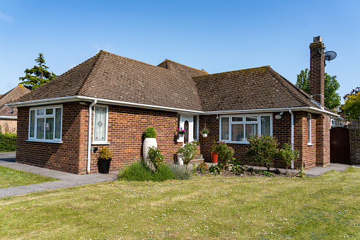 A residential brick built bungalow single storey home with a tiled roof built in 1955 and updated to include uPVC windows - UK