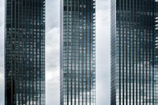 Modern skyscrapers against moody clouds forming complex block structure and pattern
