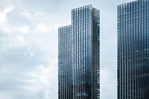 Modern skyscrapers against moody clouds forming complex block structure and pattern