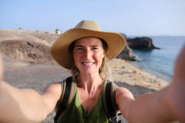 Female tourist making selfie photo with Papagayo beach on the background on Lanzarote island stock photo