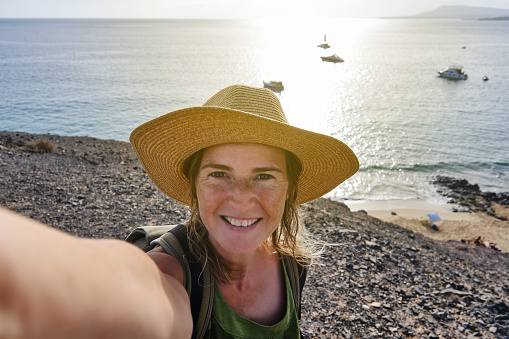 Tourist taking a selfie from a cliff on the coast during his summer holiday