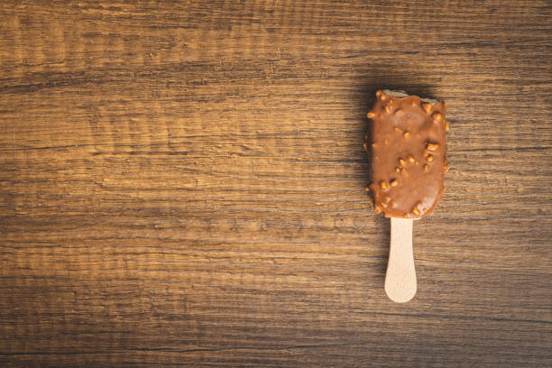 Popsicle, ice cream covered with chocolate on the wooden table. Top view.
