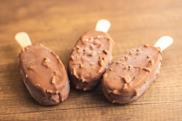 istock Popsicle, ice cream covered with chocolate on wooden table. 1497002666