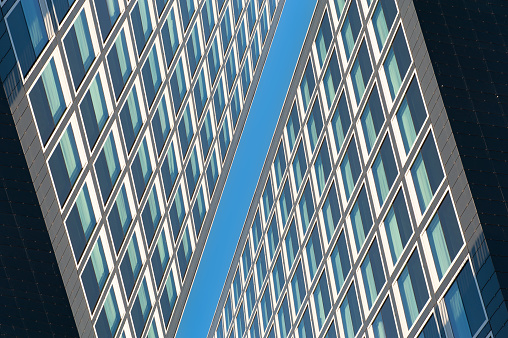 Abstract buildings meeting on clear blue sky