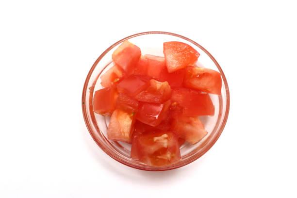 istock Chopped tomato in a glass bowl isolated on a white background. 1497008154