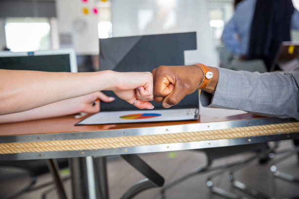 istock Two colleagues of different ethnicities join fists during a conference, agreement reached 1497011122