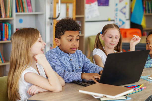 istock Multiracial group of children sitting in row at school classroom and using laptops. Back to school. 1497012465
