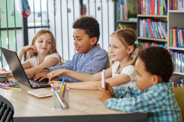 istock Multiracial group of children sitting in row at school classroom and using laptops. Back to school. 1497012493