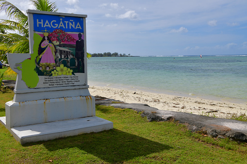 Hagåtña / Agana, Guam: city limit sign of the Guamanian capital, on South Marine Corps Drive, by the beach on Agana bay - image of Santa Marian Kamalen.