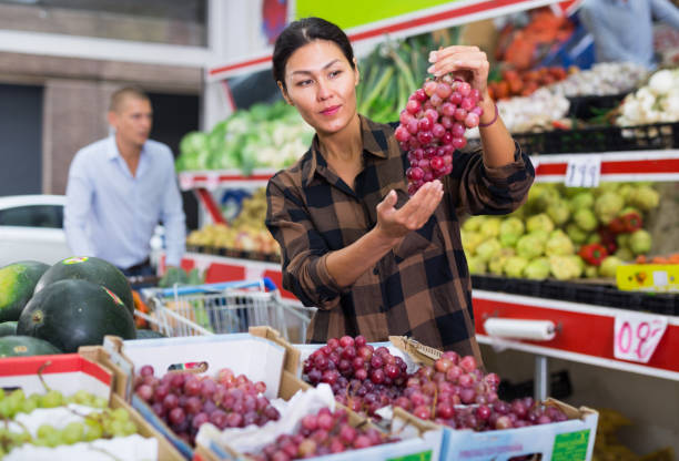 istock Woman choosing grape in greengrocer 1497015878