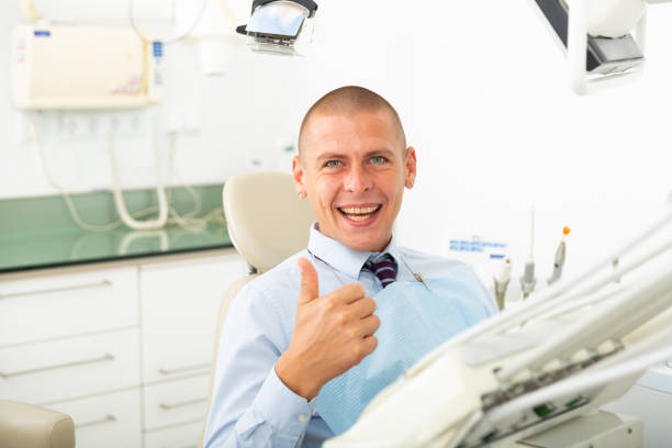istock Smiling satisfied man patient visiting dentist 1497015894